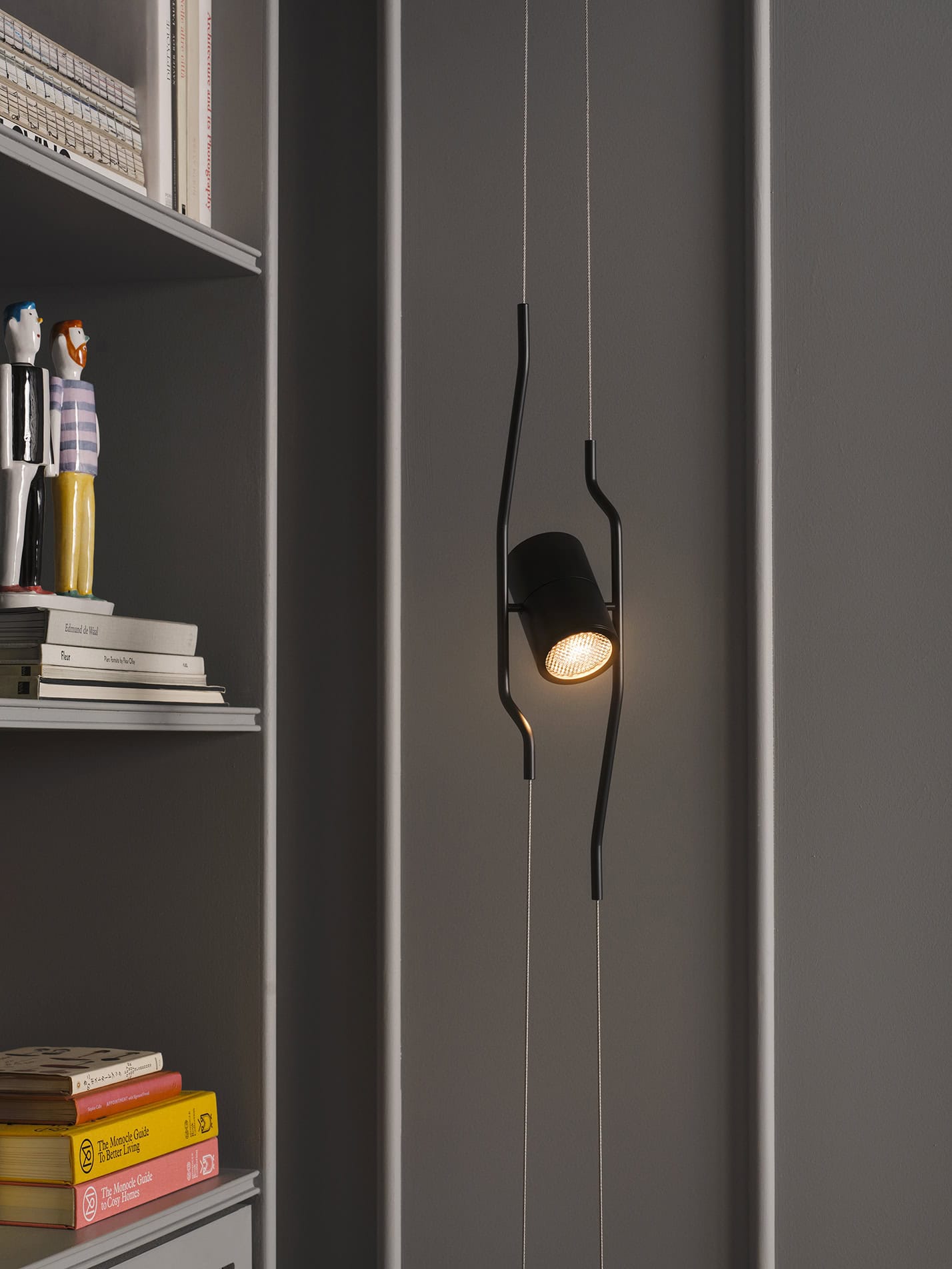 Lampada a soffitto moderna con design ondulato in nero e luce calda, ambiente elegante.